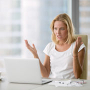 Woman at laptop hands up in frustration over doing social media herself